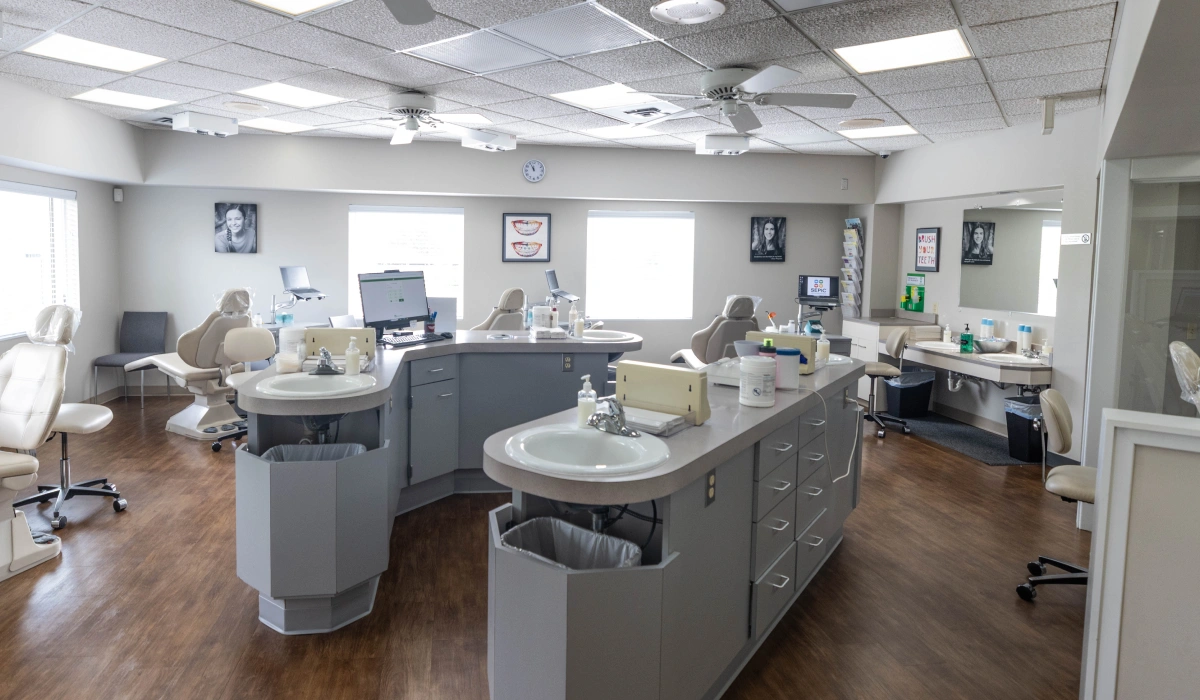 Modern orthodontic office interior with treatment chairs, dental equipment, and bright lighting throughout the clinical space.